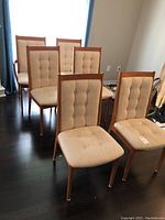 Overview of six chairs arranged on dark wood floor