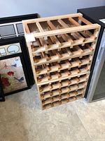 Front view of stacked wooden wine racks showing multiple horizontal slots for wine bottles, natural wood color.