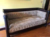 Full front view of couch showing mahogany frame, tufted upholstery and turned legs