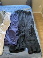 Photo showing multiple pairs of casual women's pants in black, navy blue, white, beige, and olive green colors.