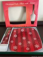 Photo of Christmas-themed glass cake plate and matching server in original red packaging with festive snowflake pattern.