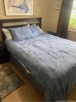 Assembled bed showing frame, mattress and bedding set