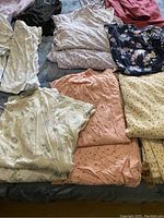 Overview photo showing several folded pyjama shirts and pants in various patterns and colors including floral, stars, and solids.