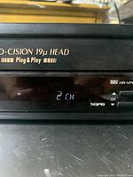 Close-up of the front panel of the JVC VHS VCR player. Shows display screen with '2 CH' channel indicator and part of the device labeling including 'Pro-Cision 19u HEAD'.