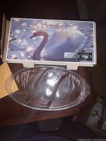 Photo of the platter in its original box showing the Swan Serenade label and the oval glass platter inside the packaging.