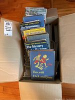 Box showing multiple hardcover books including Nancy Drew Mystery Stories and Fun with Dick and Jane.
