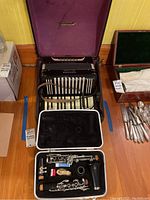 Vintage black Hohner accordion with white keys and buttons inside a purple-lined hard case, displayed open.