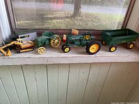 Photo of full lot showing all vintage toy vehicles lined up including tractor, wagon, excavator, and trucks.