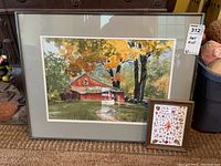Large framed colorful painting of a red barn surrounded by autumn trees and lawn with a path to the barn, matted and framed behind glass.