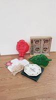 Lot of Christmas kitchen items and planters including Santa mold, green tree platter, plates, mug, ceramic pot, doily, and wooden container with jars.