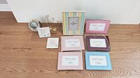 Full view of nine assorted picture frames arranged on a wooden surface, showcasing colors and styles of each frame.