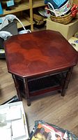 Full view of the hexagonal wooden side table showing the polished top and bamboo-style legs.