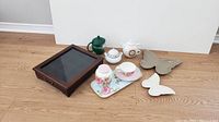 Photo showing entire lot from side angle with all items visible on floor against white wall.