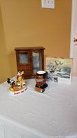 All items displayed: wooden jewellery box, unopened puzzle with wildlife birds, Disney Mickey and Pluto statue, Star Trek character mug