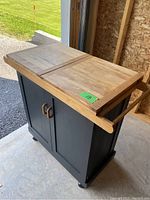 Front view showing butcher block top with two leaves, black painted base, wood handles and side towel bar