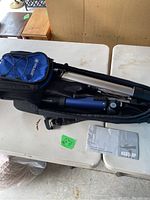 Top view showing telescope components in soft carrying bag with blue accessory pouch and manual on table.