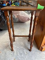 Side view of dark brown wooden table showing turned spindle legs and general structure