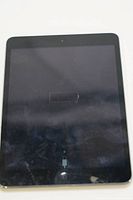 Front view of Apple iPad mini 4 showing screen with charging symbol. Screen has visible cracks in bottom right corner.