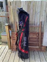 Large black and red Ping golf rolling travel cover standing upright showing full length and logo details.