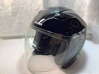 Front view of glossy copper VCAN open-face motorcycle helmet showing clear visor and interior padding.