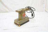 Front angled view of vintage Black & Decker finishing sander showing olive-green color, sanding base and power cord wrapped over the top.