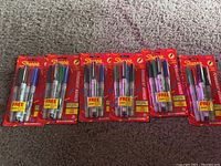 Six unopened packs of Sharpie fine point permanent markers, each with multiple colors and a free ultra fine point marker included in the package.