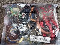 Photo of a sealed clear plastic bag showing a variety of bracelets with different colors and materials including beads and metal.