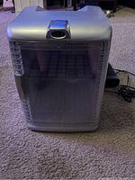 Photo showing the closed silver mini fridge with transparent door and temperature display on top.