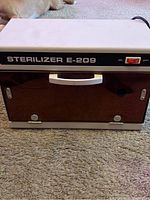 Front exterior view of the Sterilizer E-209 showing the brand label and power switch