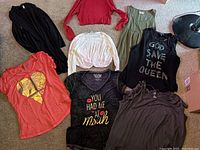 Seven women's extra large dress T-shirts arranged on floor showing different colors and prints.