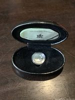 Black display case holding the sterling silver Millennium Quarter coin