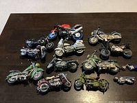 Overview of all 11 collectible miniature motorcycle models in varied styles and colors on a wooden surface.