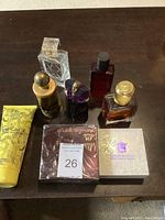 All seven items displayed on a wooden surface showing bottles of perfume and body lotion including boxed Double Diamond and Versace Yellow Diamond lotion tube