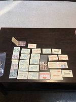 Photo showing multiple postage stamp booklets laid flat on a table with front covers visible, differing in colors and prints.