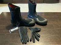 Photo showing the full set of two boots and two gloves laid out on a flat surface with the boots upright and gloves placed in front.
