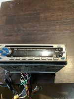 Front view of the Nextar M930 car stereo showing the silver body with control buttons and connected wiring at the back.