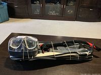 Photo showing fins, mask, and snorkel bundled together with rubber bands on a wooden table.