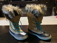 Photo showing the pair of brown winter boots with turquoise laces and faux fur trim around the opening.