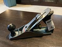 Side view of Stanley 9 inch hand planer showing metal body and black front knob.