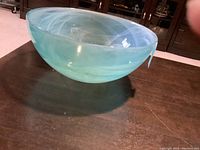 Side front view of the bluish-green Stokes bowl showing translucent swirling colors.