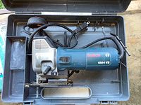 Bosch 1584 VS corded jigsaw in original gray plastic carrying case with power cord wrapped inside.