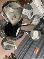 Photo of golf club heads showing Taylormade R7 Draw 460 driver, Fazer #1 driver, The Ultimate Driver by Alien, and Spalding Molitor irons.