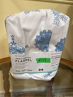 Packaged king size flannel sheet set with blue floral pattern visible on the fabric.
