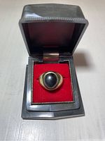 Ring displayed in hinged gray presentation box with red velvet insert