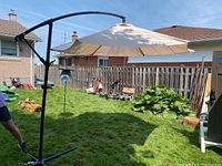 Full view of the large offset patio umbrella showing beige fabric canopy and black cantilever arm.