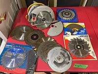 Photo showing silver Skil power saw with 7-1/4 inch blade, damaged cord, and multiple circular saw blades on red table.