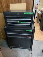 Front view of two black Waterloo tool chests stacked: top chest with five drawers on bottom cabinet with door and wheels, dimension labels visible