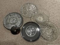 Overview of assorted crystal and glass serving platters and bowls showing various sizes and designs including round, oval, and scalloped edges.