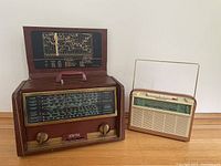 Front view of Hallicrafters tube radio with lid open showing world map chart and adjacent Philips transistor radio with extended antenna