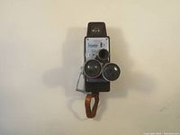 Front view showing Rondo Traveler 8T branding, three swivel lenses, viewfinder, and leather carry strap at the bottom.